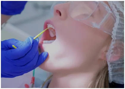 Dental professional applying a treatment to a patient's teeth